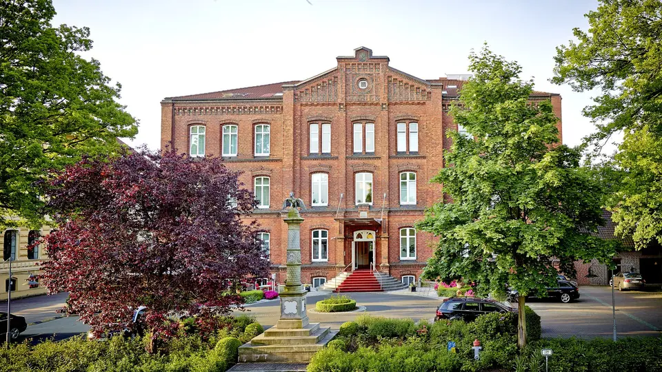 Backsteinfassade des Hotel Navigare, ehemalige Mädchenschule von 1870, mit Vorplatz und Bäumen