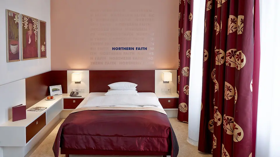 Deluxe Stadtseite mit Bett, Vorhängen und Wandbildern