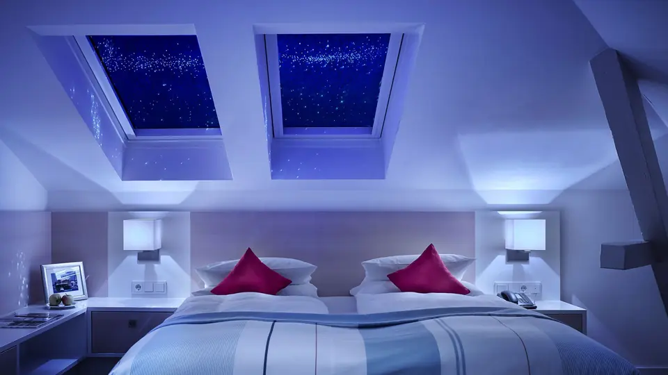 Junior Suite Brückendeck: Doppelbett unter zwei Dachfenstern mit Blick in den Sternenhimmel