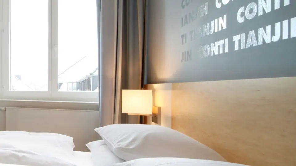 Premium Hofseite mit Doppelbett und hohem Fenster zum Hof